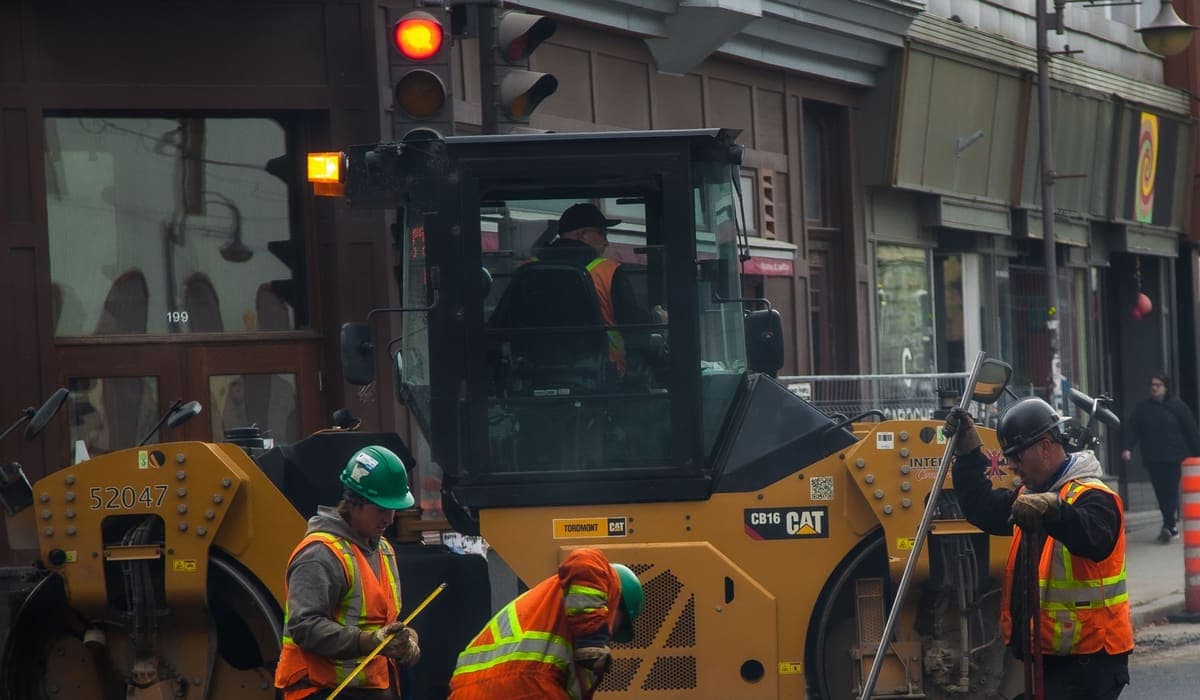 Road crew in high-visibility gear paving a street in Québec City